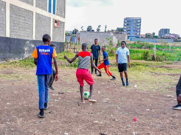 Members and children playing football at Zion Children's Home Visit